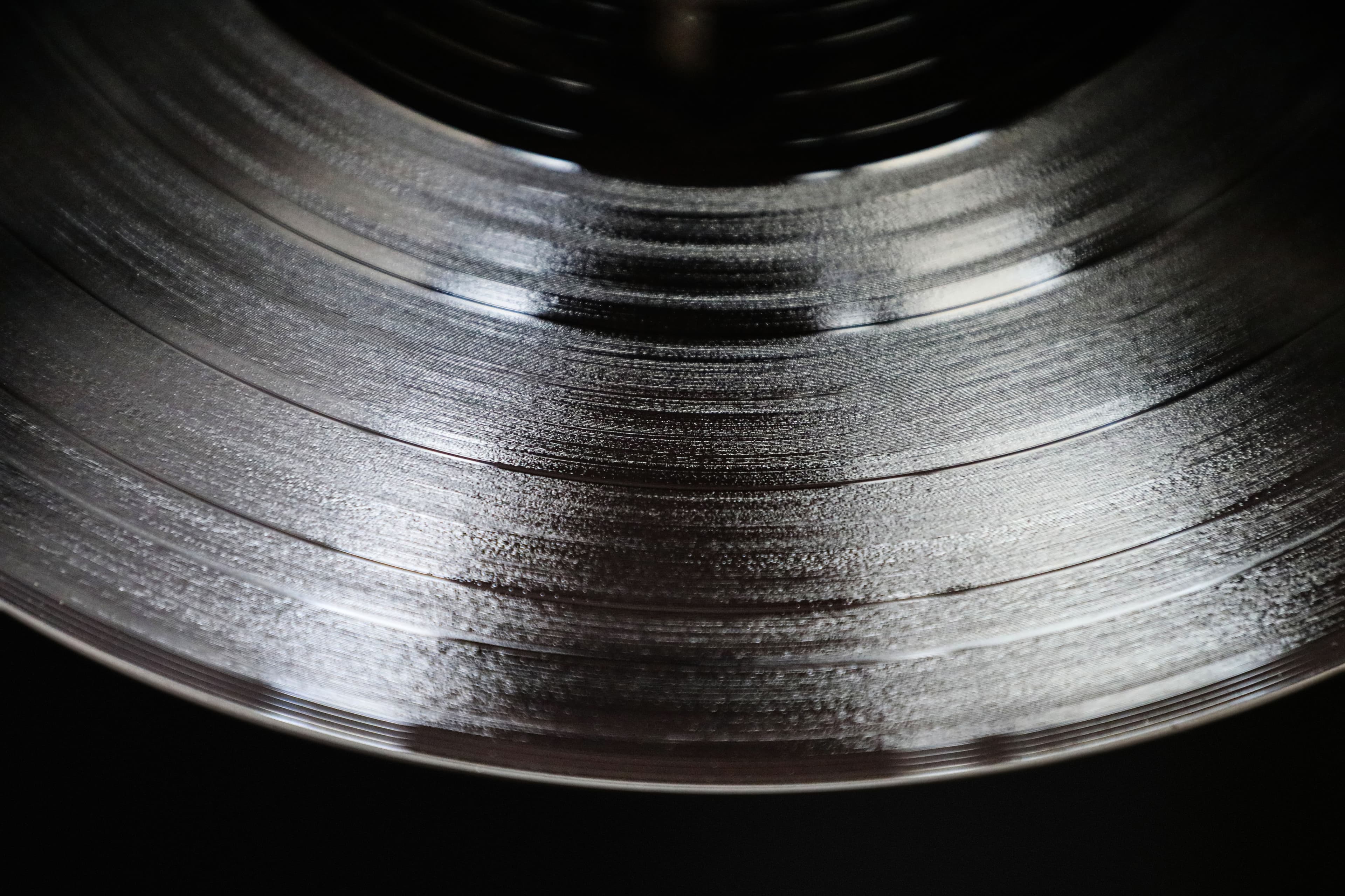 Macro photograph of vinyl record grooves catching the light